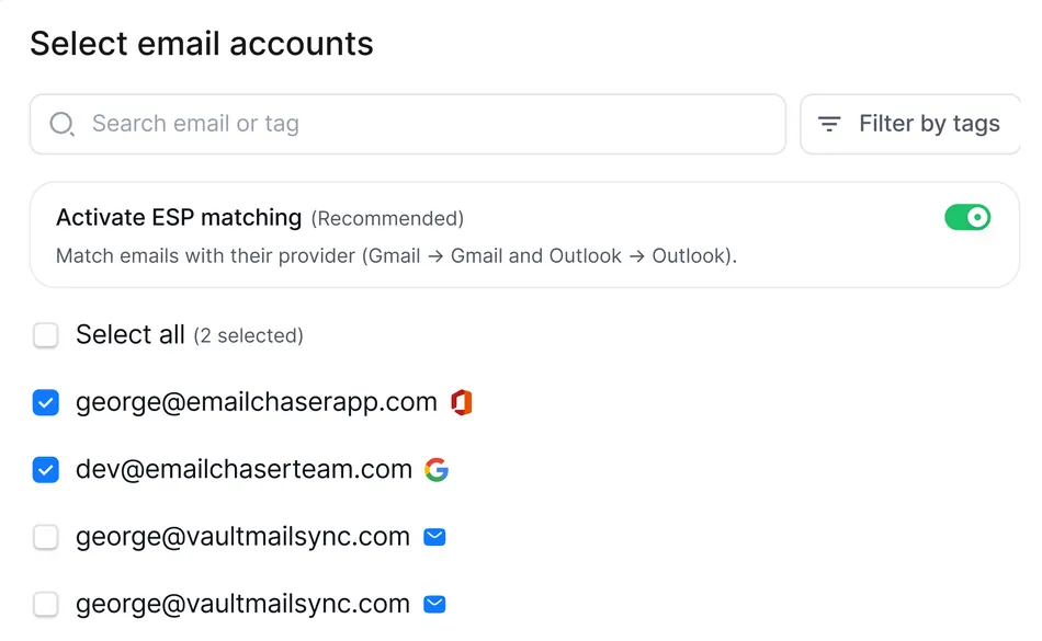 A screenshot displays a mobile interface titled 'Select email accounts.' It features a search bar for email or tags and a 'Filter by tags' button. Below, there's a toggle option to 'Activate ESP matching' which is recommended to match emails with their provider, like Gmail to Gmail and Outlook to Outlook. A 'Select all' checkbox is available, indicating 2 accounts are currently selected. Two email addresses, george@emailchaserapp.com with an Outlook icon and dev@emailchaserteam.com with a Google icon, are checked. Below these, two unchecked email addresses, george@vaultmailsync.com each with a blue envelope icon, are listed.